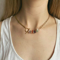 Ce collier upcyclé asymétrique en plaqué or, orné de pierres semi-précieuses (quartz roses, verts et transparents, agates et améthystes) a été fabriqué à la main dans notre atelier strasbourgeois.