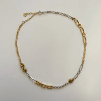 On voit le collier fait main et ses différentes mailles de qualité posé sur un fond blanc