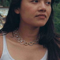 une photo portée du collier d'un peu plus près, on voit le détail des maillons torsadés, des teintes du plaqué or et de l'argent qui se mélangent.
