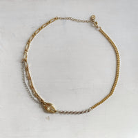 Photo du collier sur fond blanc. On voit en détail chaque maille de toutes les chaînes vintages qui composent le collier unique.