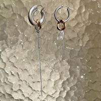 Les boucles d'oreilles asymétriques upcyclées Tête d'Orange, elles sont suspendues pour montrer leur longueur.
