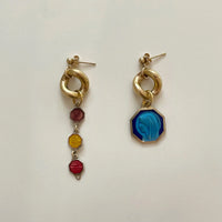 les boucles d'oreilles upcyclées sont posées sur fond blanc.
