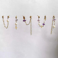 Les cinq boucles d'oreilles upcyclées Iris, toutes suspendues sur un fil horizontal. 