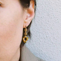 La modèle porte la deuxième boucle d'oreille, celle composée d'un bout de chaîne grain de café et d'un maillon plaqué or vintage.