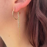 Photo portée de la première boucle d'oreille. On voit le mélange des métaux dorés et argentés, le contraste doux qui est créé.