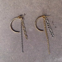 Photo des boucles d'oreilles sur fond texturé marron. On voit que les chaînes en argent et plaquées or sont attachées au fermoir de la créole plaquée or.
