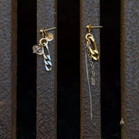 La paire de boucles d'oreilles upcyclées posée sur un fond texturé citadin marron.
