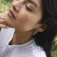la boucle d'oreille avec le médaillon vintage doré portée par notre modèle.