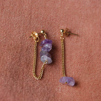 boucles d'oreilles upcyclées pendantes composée de chaînes et d'améthystes. Cette paire de boucles d'oreilles repose sur un fond en velours vieux rose
