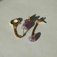 boucles d'oreilles upcyclées pendantes composée de chaînes et d'améthystes. Cette paire de boucles d'oreilles repose sur un fond blanc
