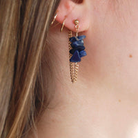 Boucles d'oreilles upcyclées ornées de lapis lazulis portées à une oreille.