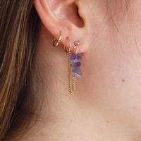 boucles d'oreilles upcyclées ornées d’améthystes portée à une oreille.