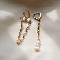 Boucles d'oreilles en plaqué or avec des chaînes pendantes et des perles d'eau douce. Les fermoirs sont des fermoirs dormeuse.