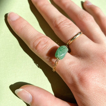 Bague upcyclée ornée d'un quartz vert portée au doigt