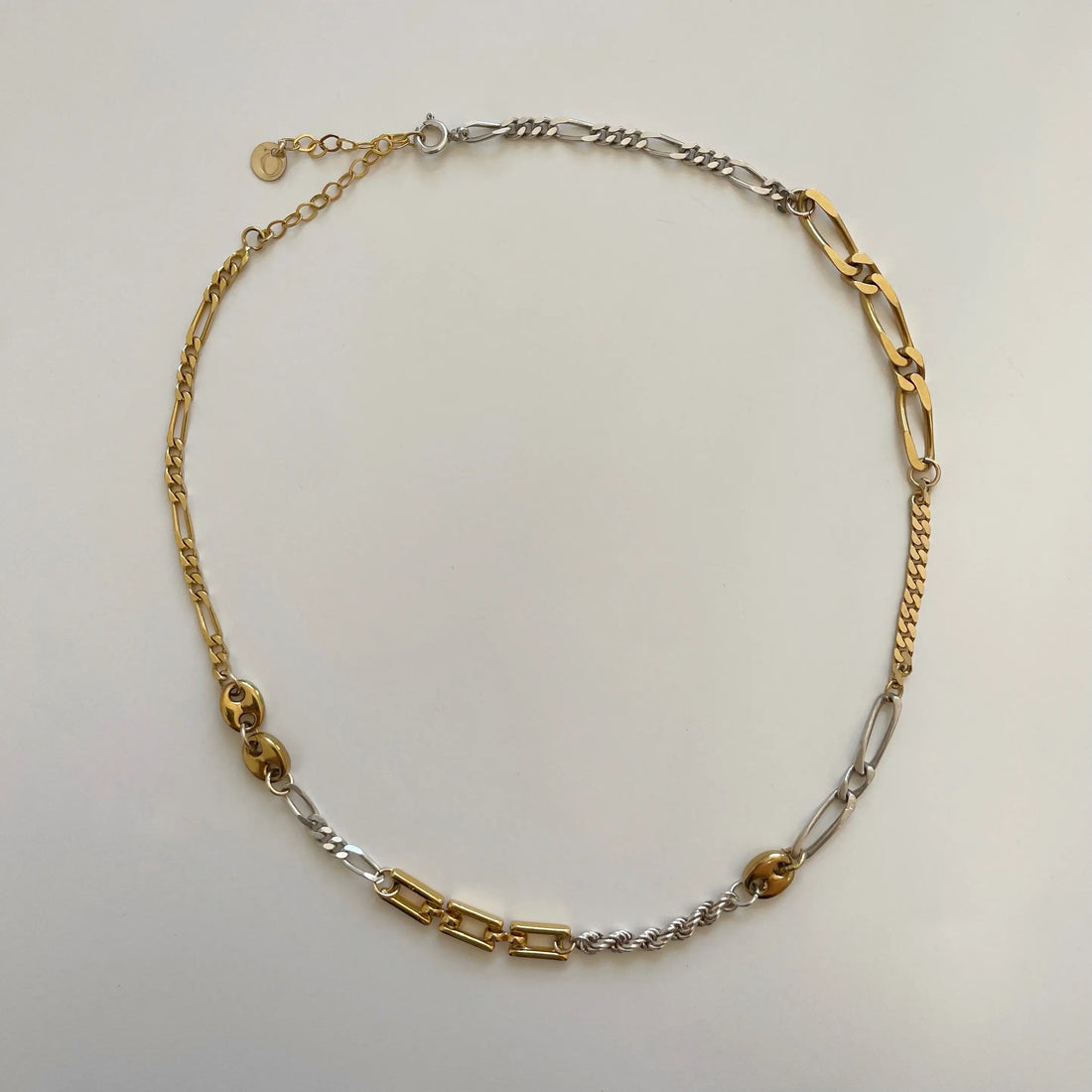 On voit le collier fait main et ses différentes mailles de qualité posé sur un fond blanc