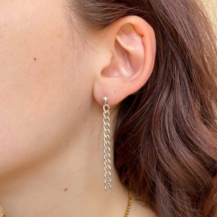 la deuxième boucle portée composée d'une chaîne vintage argent pendente.
