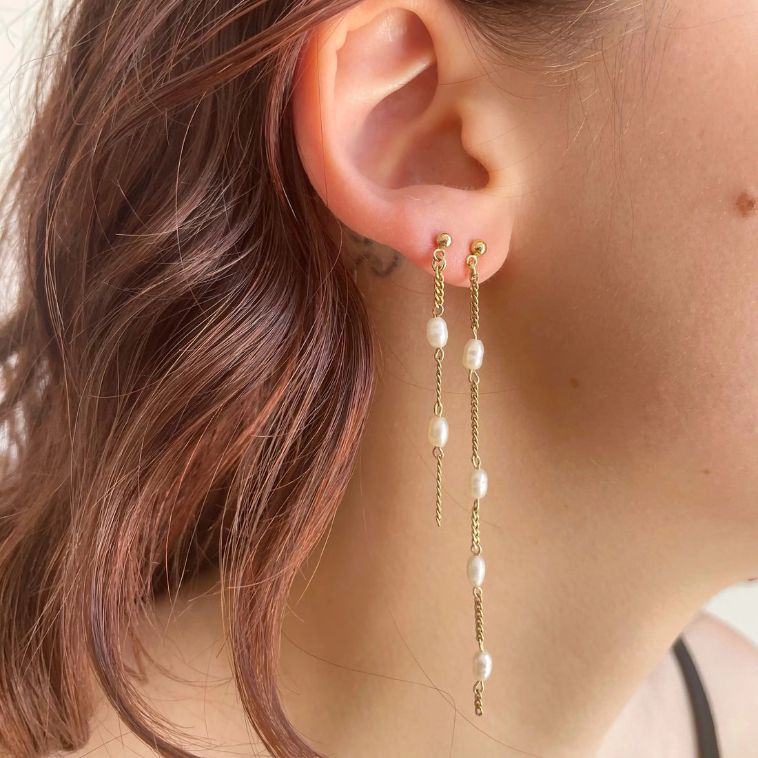 Les deux boucles sont portées sur la même oreille. On voit l'alternance entre les chaînes fines plaquées or et les petites perles d'eau douce.