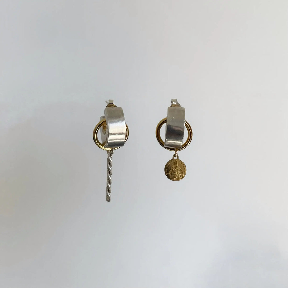 créoles massives en argent, l'anneau doré qu'on apercoit faire le tour de la créole et chaîne ou médaillon pendent.