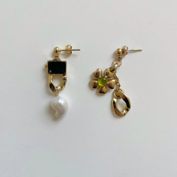 Photo des boucles d'oreilles asymétriques uniques sur fond blanc. 