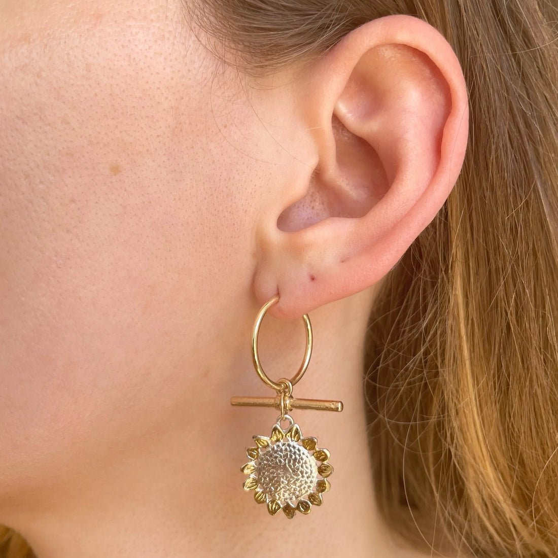 photo portée de la boucle d'oreille upcyclée qui mélange plaqué or et argent