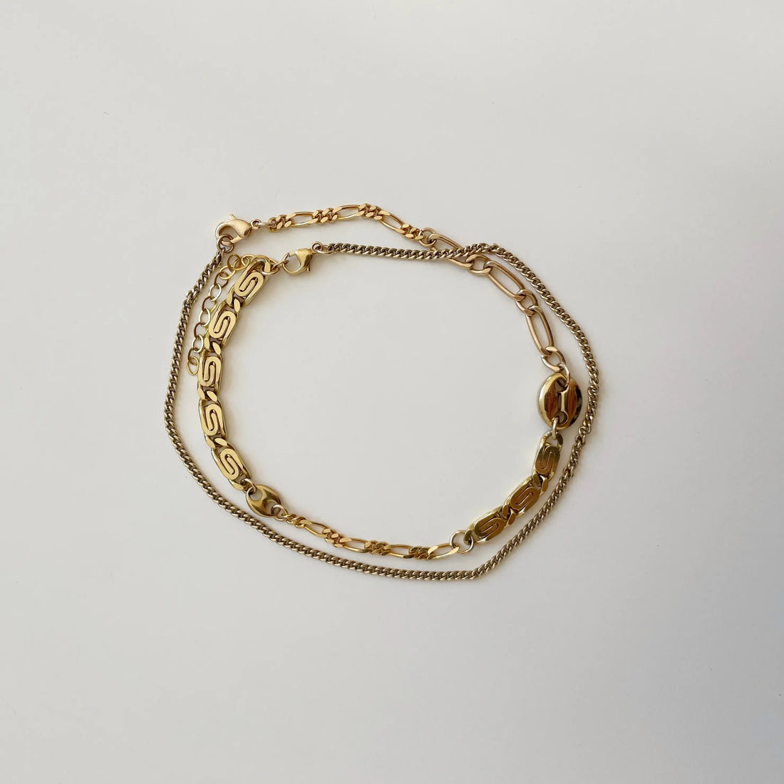 le bracelet de cheville upcyclé entièrement plaqué or posé sur un fond blanc.