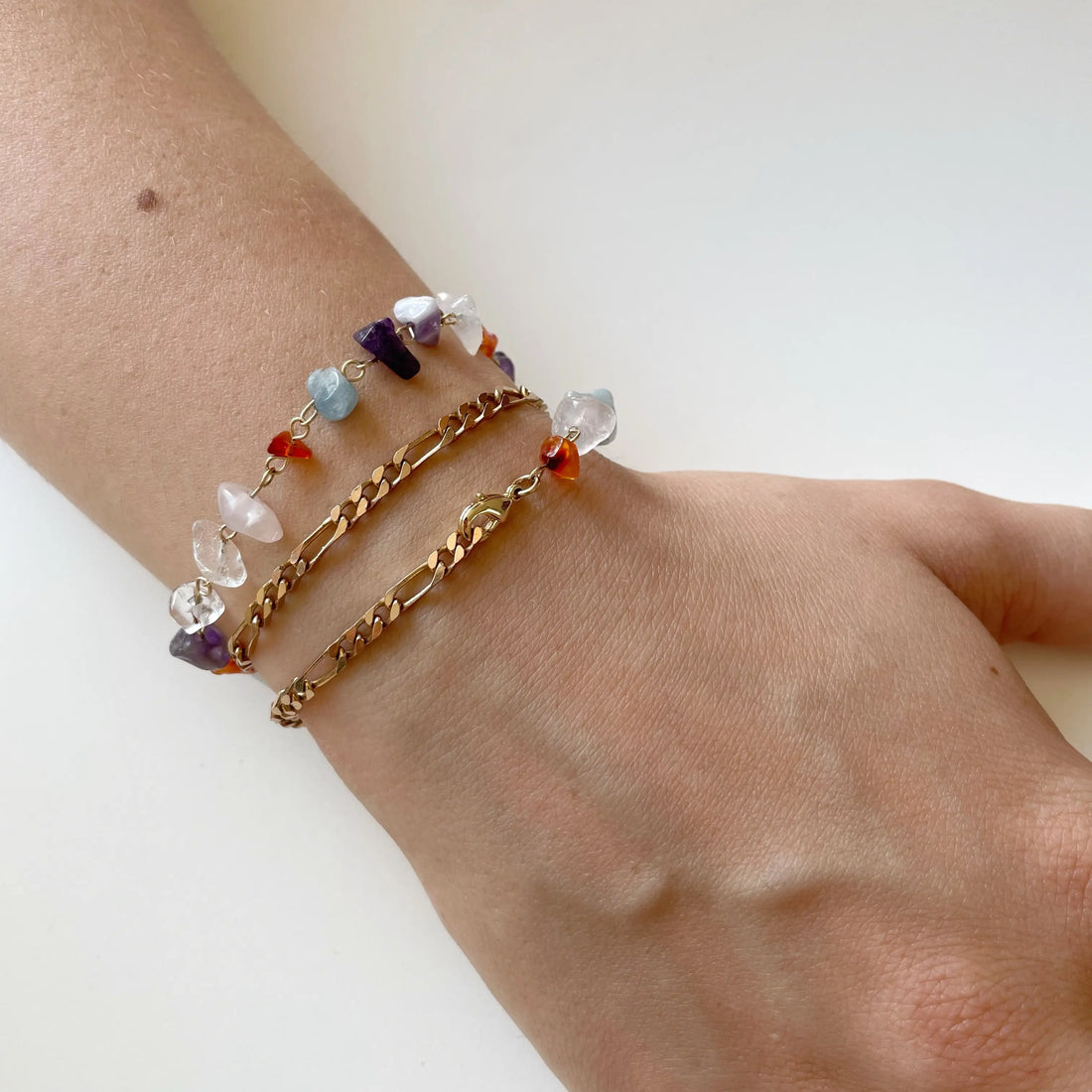 Photo portée du bracelet au poignet. La chaîne vintage fait deux fois le tour du poignet et les pierres colorées complètent avec gaieté cet ensemble.