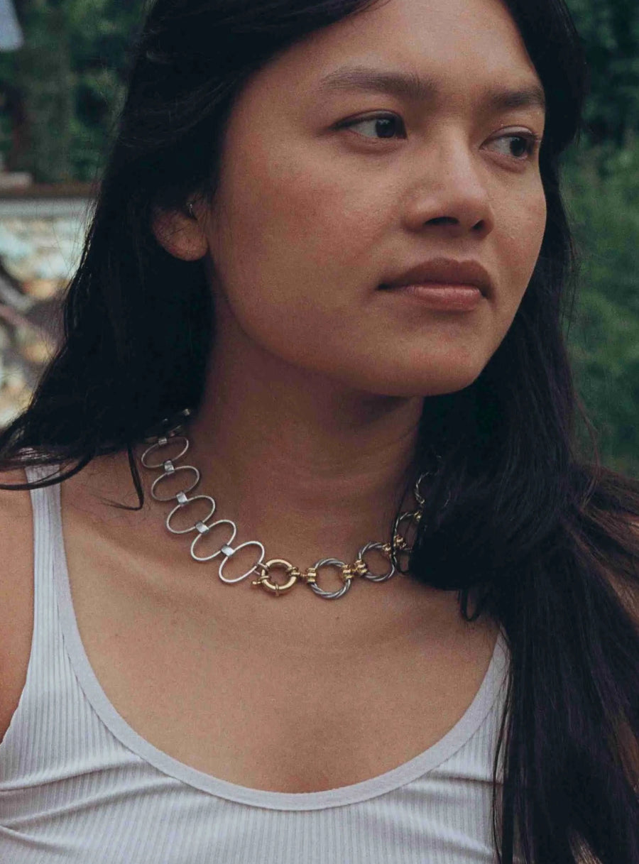 une photo portée du collier d'un peu plus près, on voit le détail des maillons torsadés, des teintes du plaqué or et de l'argent qui se mélangent.