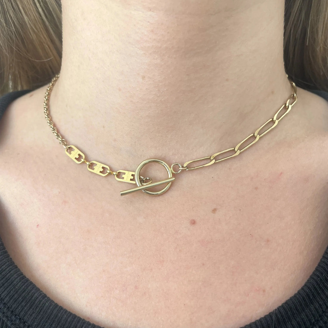 Ce collier upcyclé, réalisé avec un mélange de chaînes plaquées or et orné d'un fermoir en T en gold-filled.