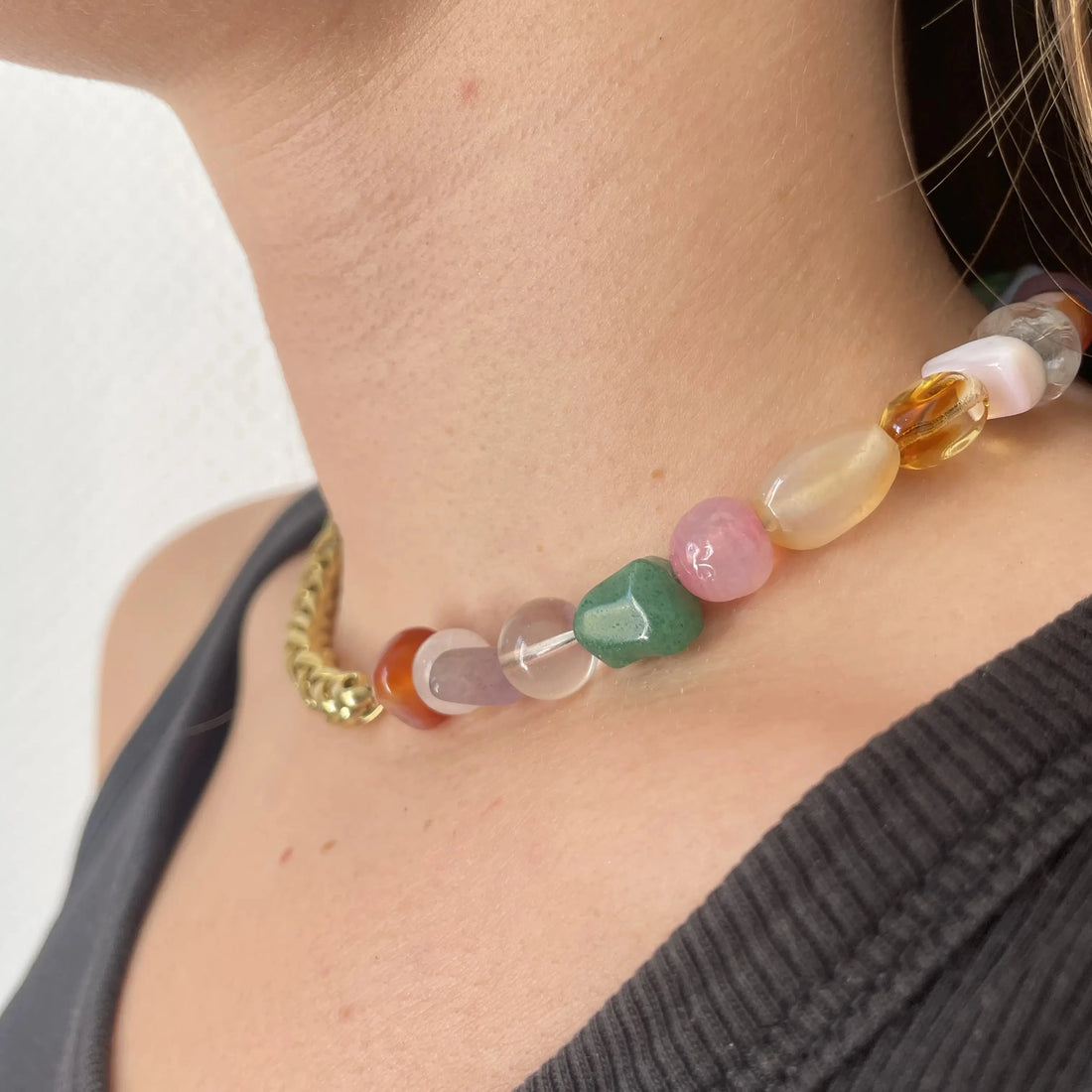 Ce collier upcyclé, réalisé avec une grosse chaîne torsadée plaquée or et des pierres semi-précieuses comme le quartz, la cornaline et l'améthyste