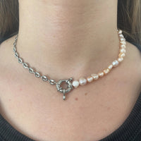 Ce collier upcyclé asymétrique, réalisé avec une chaîne grain de café en acier inoxydable et des perles d’eau douce rose.