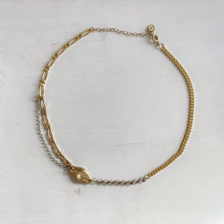 Photo du collier sur fond blanc. On voit en détail chaque maille de toutes les chaînes vintages qui composent le collier unique.