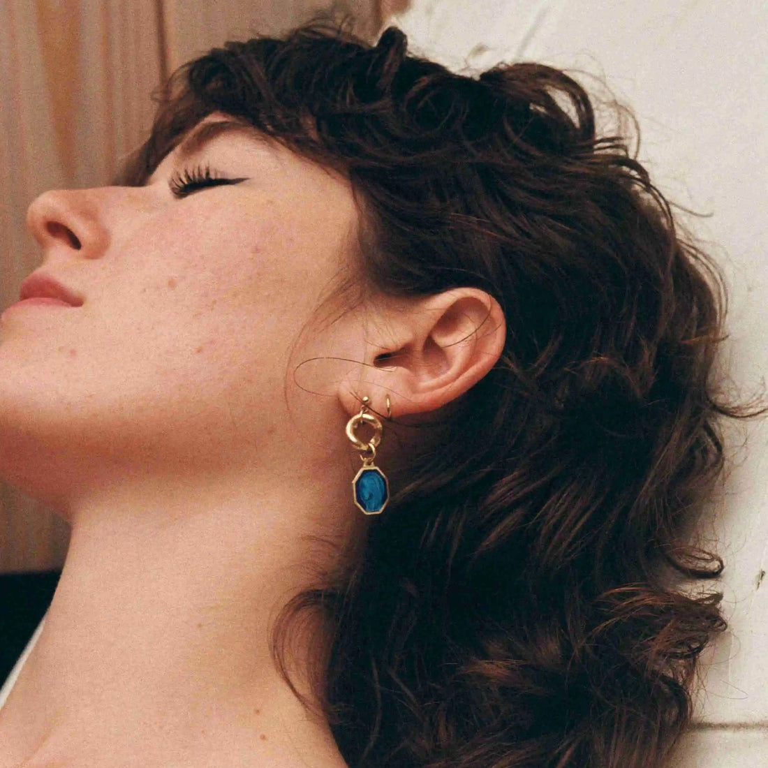 la modèle porte la boucle d'oreille avec le médaillon vintage bleu