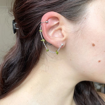 Mono boucle, qui associe une chaîne en argent 925 à des pierres semi-précieuses de couleur verte.