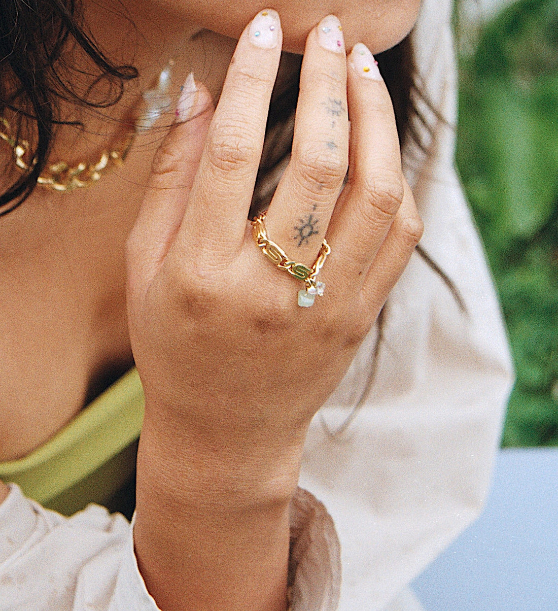 La bague unique est portée par notre modèle. On voit la chaîne faire le tour du doigt.