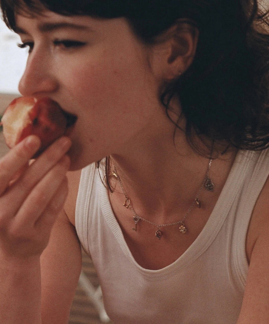 Photo portée du collier, on voit la délicatesse de chaque petit pendentif qui s'harmonisent sur le cou de notre modèle.