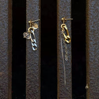 La paire de boucles d'oreilles upcyclées posée sur un fond texturé citadin marron. 