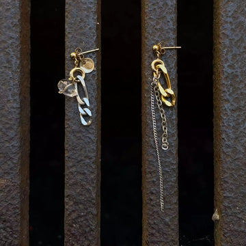 La paire de boucles d'oreilles upcyclées posée sur un fond texturé citadin marron. 