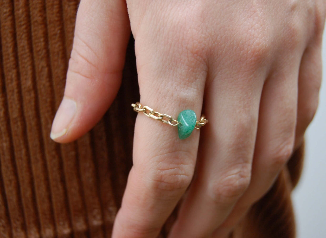 Bague upcyclée ornée d'un quartz vert portée à un doigt