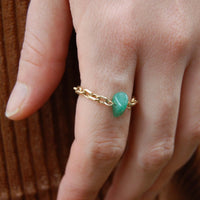 Bague upcyclée ornée d'un quartz vert portée à un doigt