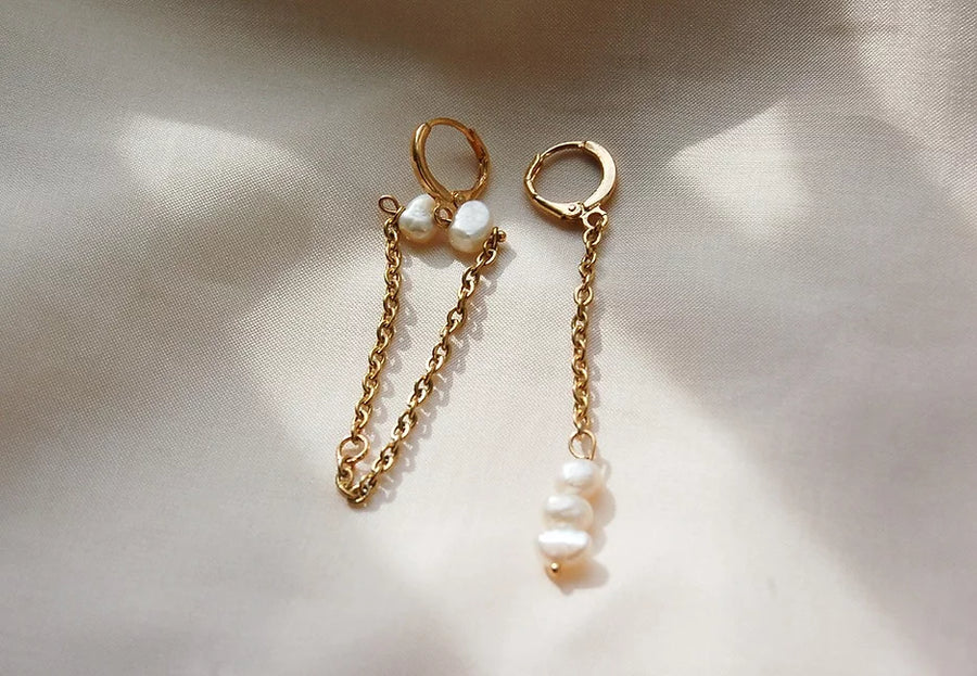 Boucles d'oreilles en plaqué or avec des chaînes pendantes et des perles d'eau douce. Les fermoirs sont des fermoirs dormeuse. 